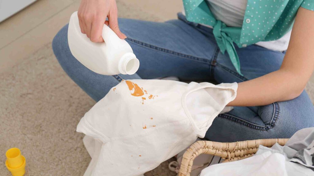 A woman uses special detergent to remove a stain from a white shirt.