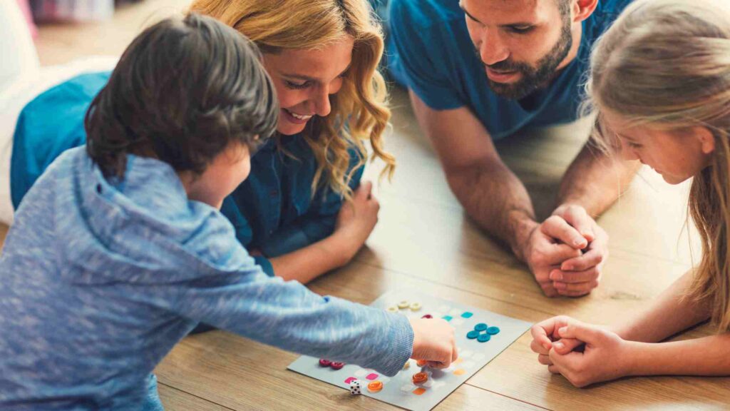 A family plays a board game after regaining time from using a wash and fold service in Northern NJ.